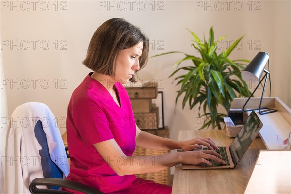 Profile photo of a serious specialist nutrition female doctor uses her laptop to attend to patients online