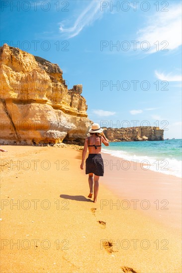 A female tourist strolling on the beach at Praia da Coelha