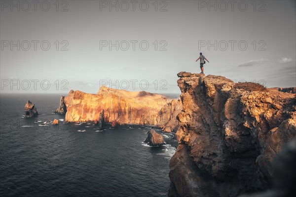 A young man in Ponta de Sao Lourenco on the coast with rock formations