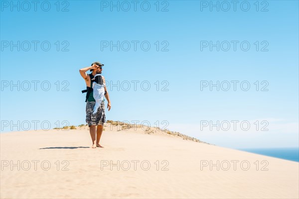 A young man enjoying the summer with his son on the sand dune at Monsul beach in the Cabo de Gata Natural Park