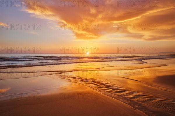 Atlantic ocean sunset with surging waves at Fonte da Telha beach