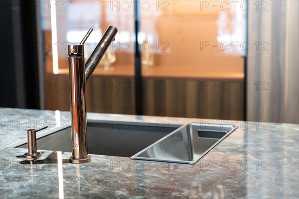 A modern faucet and sink in a trendy kitchen. Mid shot