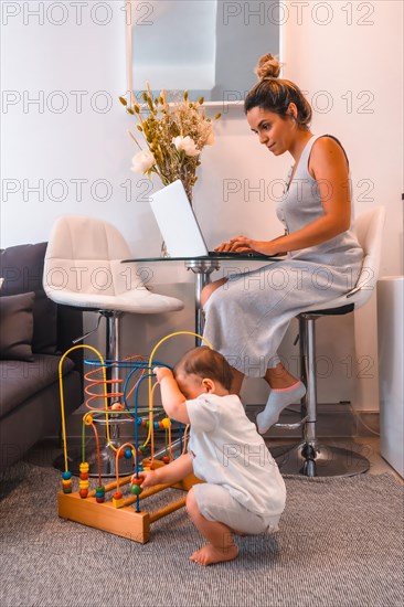 Young Caucasian mother caring for her young son and teleworking