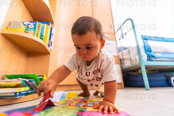 Young Caucasian mother playing with her in the room with toys. Baby less than a year learning the first lessons of her mother. Boy playing on the floor with toys