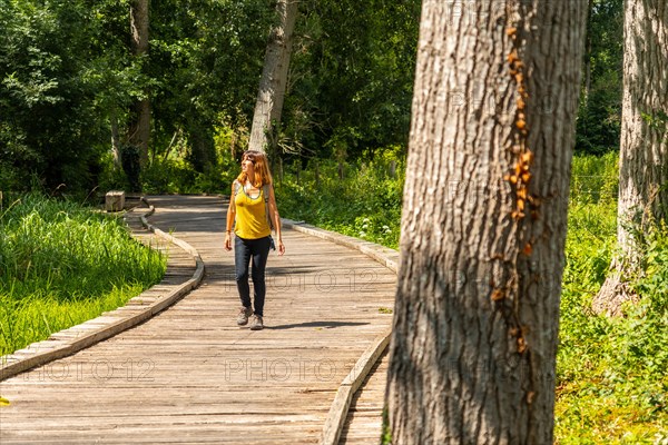 A young woman trekking on the footpath along a footbridge between La Garette and Coulon