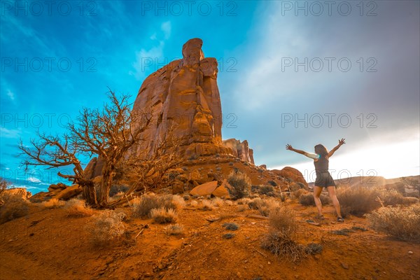 Beautiful figures of giant stones inside the Monument Valley National Park and a lifestyle girl with black shirt and raised arms. Utah