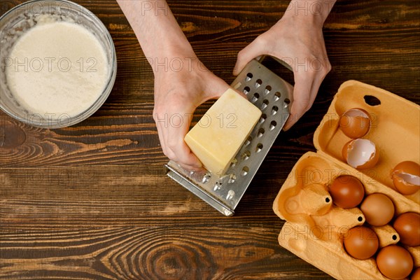 Male hands using grater for cheese