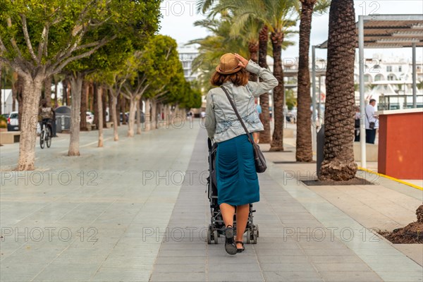 A mother with her daughter in the palm tree park in San Antonio Abad in the port