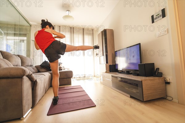 A young woman doing sports in her living room. Sport in the quarantine at home