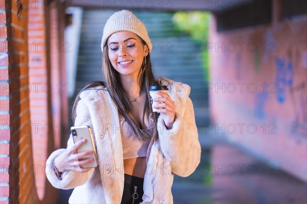 Young pretty Caucasian brunette in the city making a video call on the phone