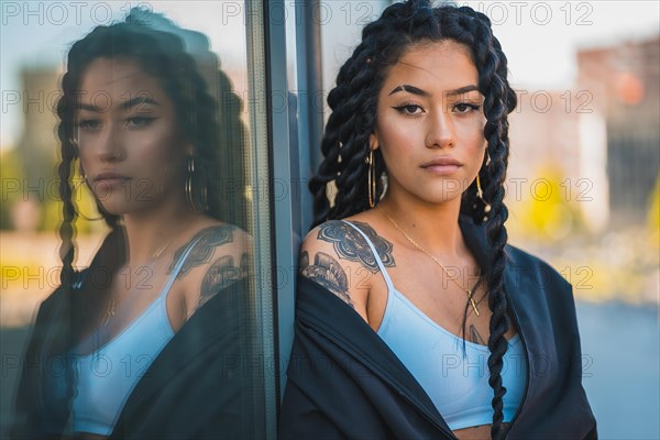 Urban session. Young woman of black ethnicity with long braids and with tattoos