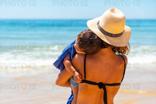 Mother sleeping her son by the sea on vacation
