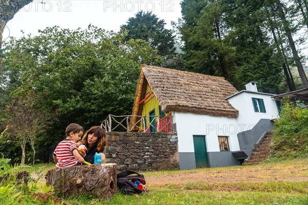 A family in the traditional Madeiran house like those of Santana in the forest of Caldeirao Verde