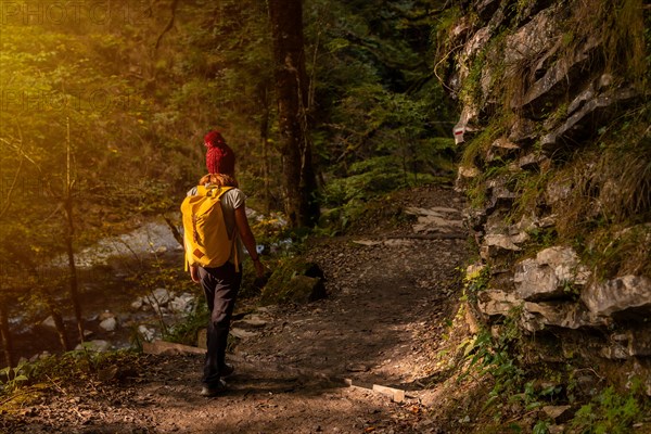 A young woman at sunset on the path to the Holtzarte suspension bridge