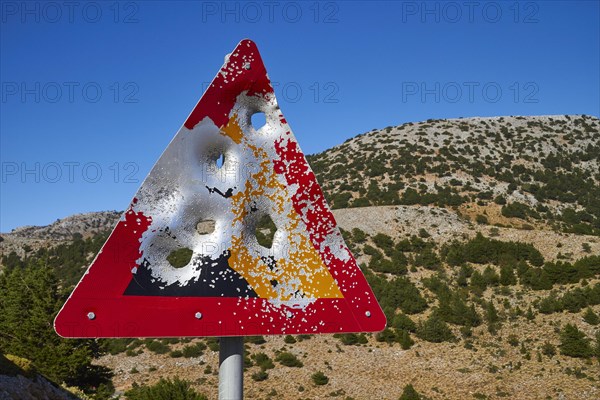 Shot triangular warning sign