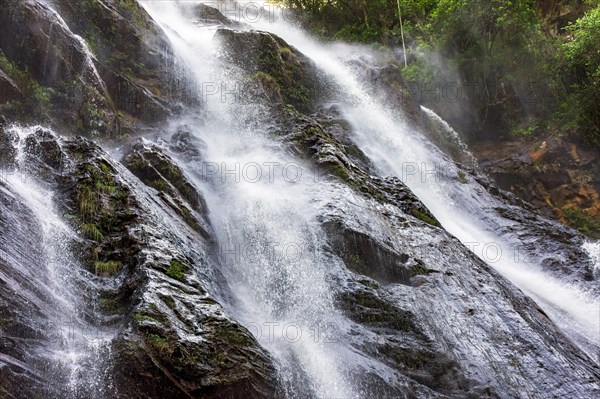 Beautiful waterfall with water flowing between the rocks and the forest in Minas Gerais