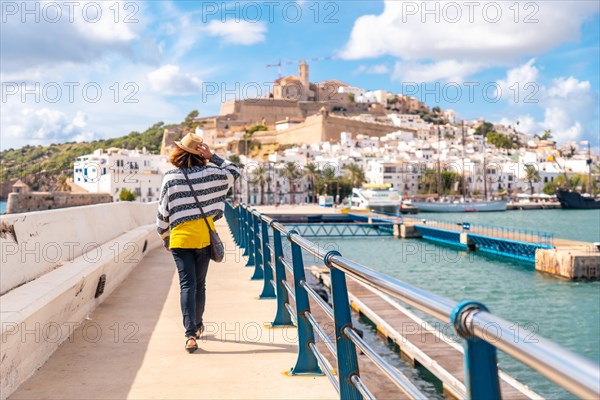 A young woman visiting coastal Ibiza town on winter vacation from Al Faro