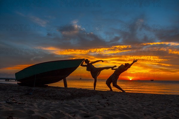 A couple playing at Roatan Sunset from West End. Honduras