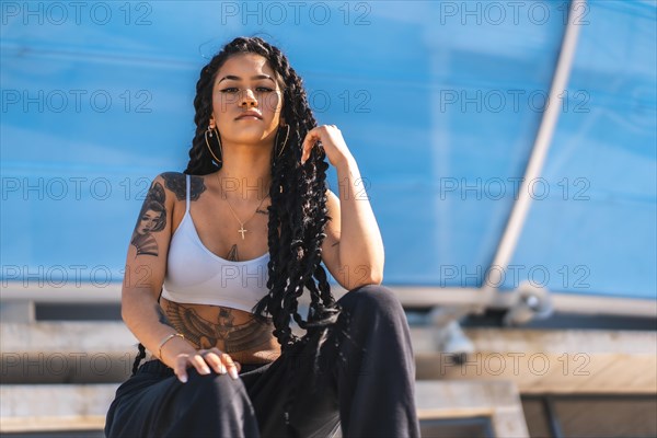 Young black woman with long braids and tattoos