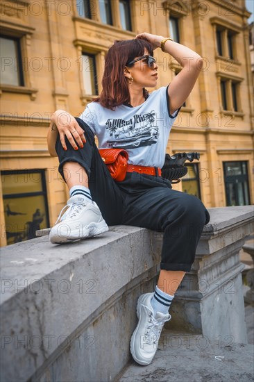 Lifestyle in the city. A young brunette in sunglasses