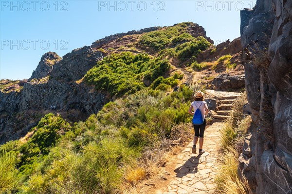 A young woman walking towards Pico do Arieiro from Ninho da