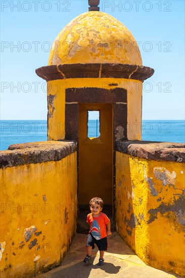 A boy having fun in the watchtower at the Forte de Sao Tiago fort in Funchal. Madeira