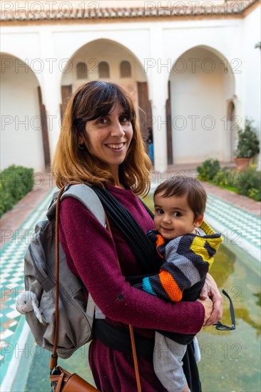 A young woman visiting the courtyard with water fountains inside the Alcazaba in the city of Malaga