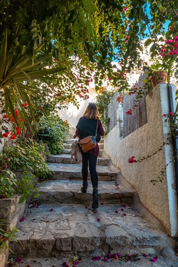 A young woman walking between houses in Mojacar with white houses on the top of the mountain. Costa Blanca in the Mediterranean Sea