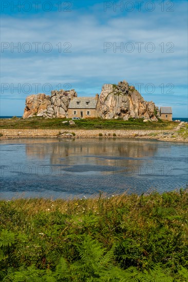 House among rocks next to a beautiful lake