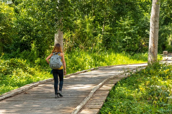 A young woman on the footpath along a footbridge between La Garette and Coulon