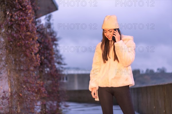 Young pretty Caucasian brunette walking in the city in winter