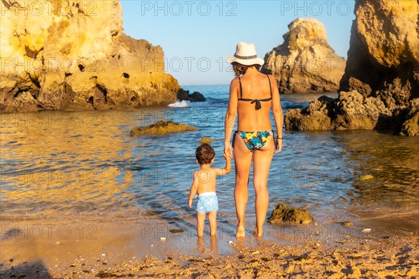 A mother with her baby in the water at Praia dos Arrifes