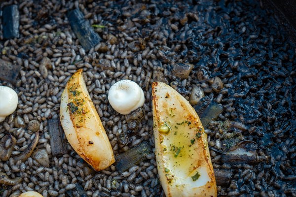 Detail of the black rice with cuttlefish and young garlic