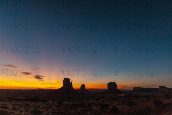 Panoramic of the first pink sunrise lights at Monument Valley in the beautiful August sunrise