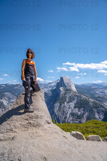 A young woman in pink and black at the Glacier point on the Half Dome wall. Yosemite National Park