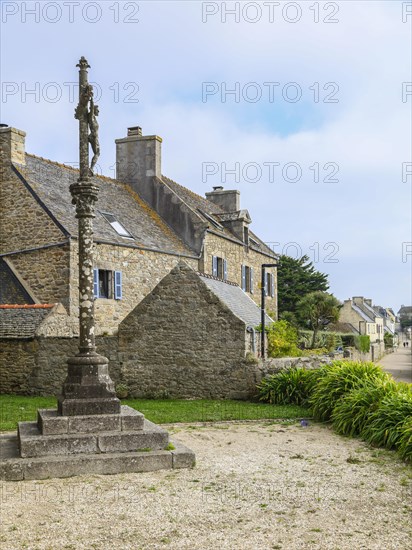 Calvaire in front of the church Eglise Notre-Dame-du-Bon-Secours and stone house