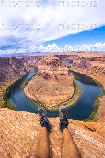 Crossed feet resting watching Horseshoe Bend and the Colorado River in the background