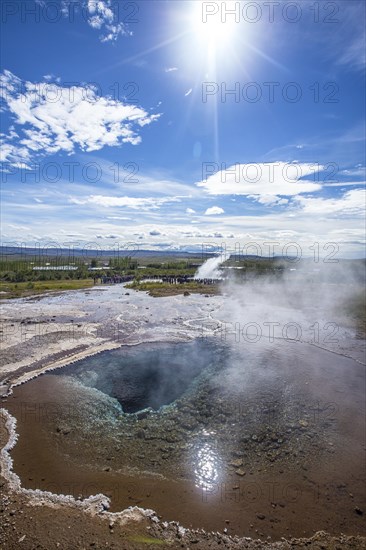 Geysir Strokkur with the sun in the background of the golden circle of the south of Iceland