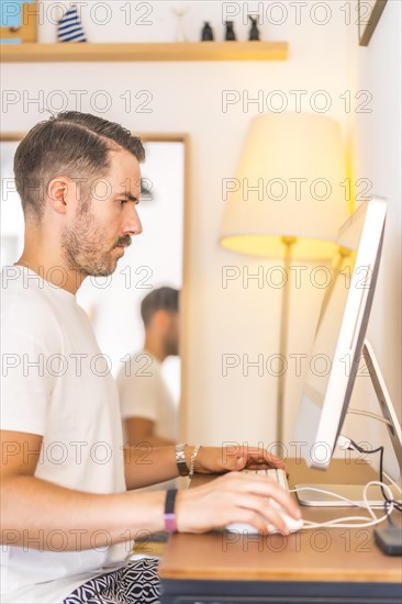 A young man teleworking from home in a work video conference