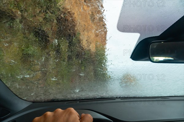 Water on top of the car driving inside a car at Anjos Waterfall