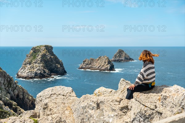 A young tourist girl looking at the sea at Pen Hir Point on the Crozon Peninsula in French Brittany