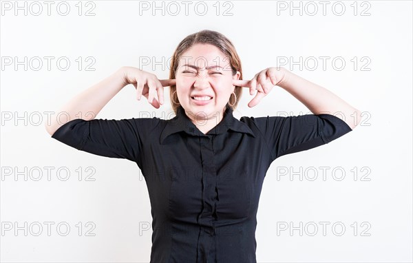 Displeased young woman covering her ears isolated. Latin girl covering her ears tightly isolated