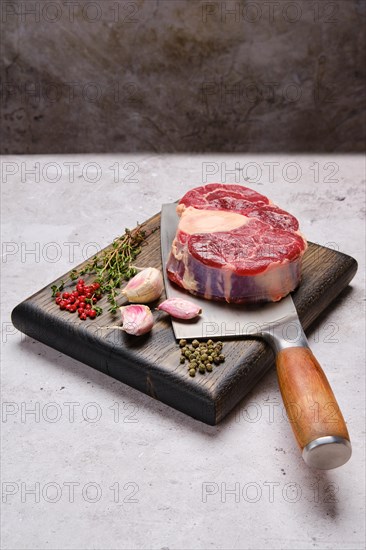 Big piece of raw beef shank cross-cut on cleaver with spice and herb