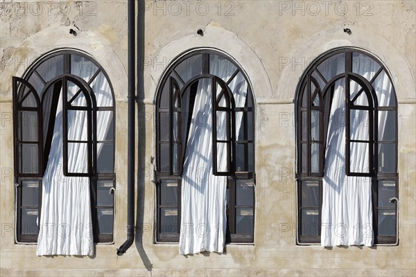 Window front with white curtains in historical building