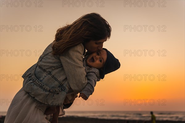 A young mother kissing her son at the Toston Lighthouse Sunset