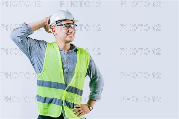 Worried builder engineer holding his head isolated. Troubled young engineer holding his head looking up. Worried male engineer man holding his head