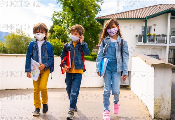 Three brothers with face masks ready to go back to school. New normality