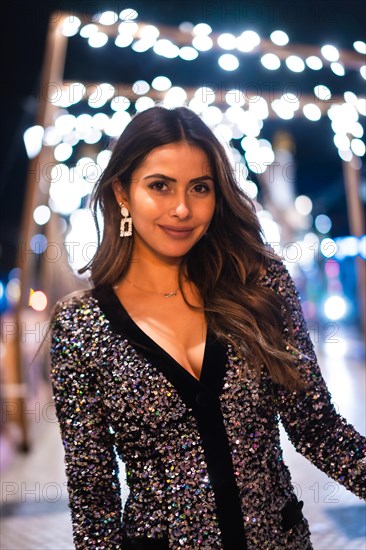 Christmas lifestyle. Portrait a young brunette Caucasian woman in a fashionable dress with sequins