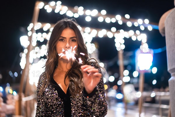 Winter lifestyle at Christmas. Brunette Caucasian girl in a fashionable dress with sequins