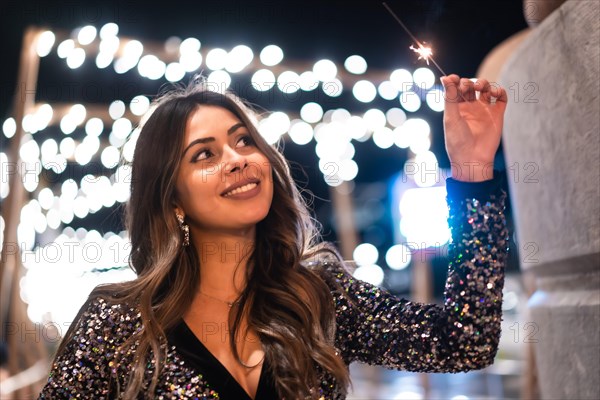 Winter lifestyle at Christmas. Brunette Caucasian girl in a fashionable dress with sequins